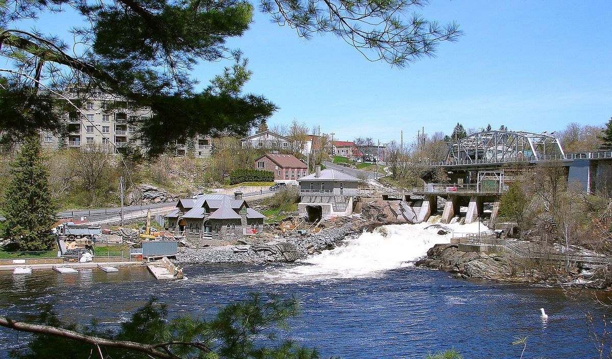The town of Bracebridge, Ontario, with its steel bridge, falls and buildings climbing the hill.